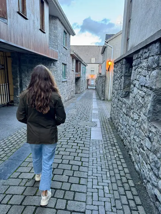 Romina spaziert durch eine schmale Gasse