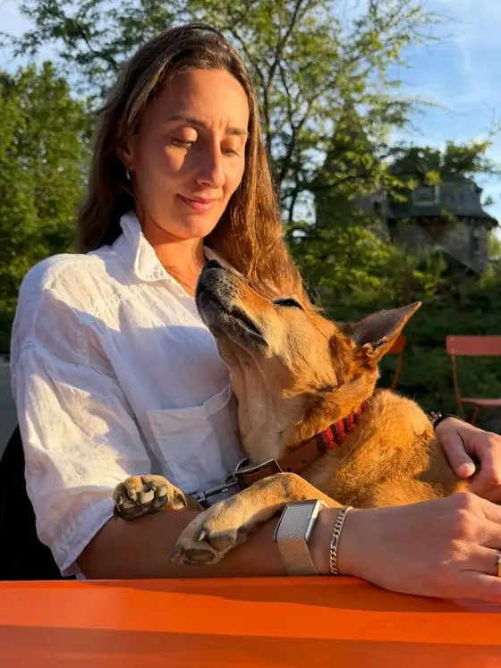 Romina hält ihren Hund im warmen Abendlicht