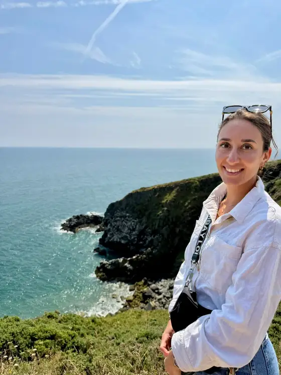 Romina am Meer, mit Küste und weitem Horizont im Hintergrund
