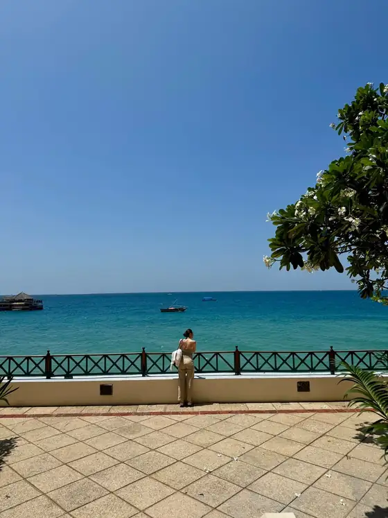 Romina schaut von einer Terrasse auf das Meer
